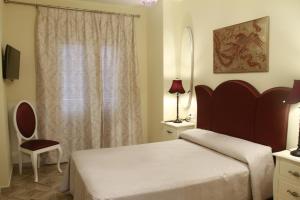 コニル・デ・ラ・フロンテーラにあるHostal Flor De Lis- Lojoのベッドルーム1室(ベッド1台、椅子、窓付)