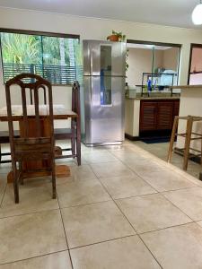 a kitchen with a stainless steel refrigerator and a table at Casa em Bonito in Bonito +5 photos