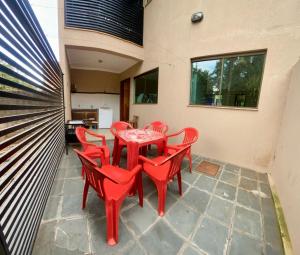 a red table and chairs on a patio at Casa em Bonito in Bonito