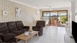 un salon avec des canapés et une table dans l'établissement Peninsula Court Unit 10, à Yamba