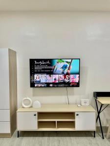 a living room with a tv on a white wall at Nuvali - Free use of Massage Chair-Pool Access-Hot Shower in Calamba