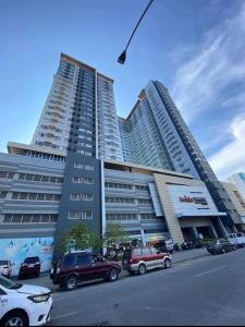 un grand bâtiment avec des voitures garées devant dans l'établissement Relax in Style Walk into City, Roxas Market with Pool, à Davao 23 autres photos