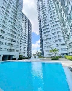 une piscine devant deux grands immeubles dans l'établissement Relax in Style Walk into City, Roxas Market with Pool, à Davao
