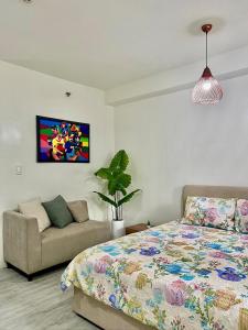 a bedroom with a bed and a couch at Nuvali - Free use of Massage Chair-Pool Access-Hot Shower in Calamba