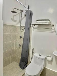 a bathroom with a shower with a toilet and a sink at Nuvali - Free use of Massage Chair-Pool Access-Hot Shower in Calamba