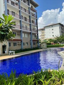 a swimming pool in front of a building at Nuvali - Free use of Massage Chair-Pool Access-Hot Shower in Calamba