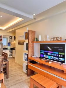 un salon avec une grande télévision à écran plat dans l'établissement Relax in Style Walk into City, Roxas Market with Pool, à Davao