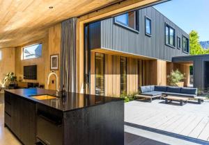 a modern house with a kitchen and a living room at Haehaenui Retreat - with Stoked hot tub in Arrowtown