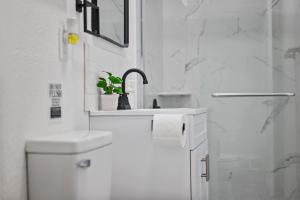 a white bathroom with a sink and a toilet at Bloomfield Pittsburgh A Modern and Cozy Private Bedroom, Shared Bathroom, with Free Parking in Pittsburgh