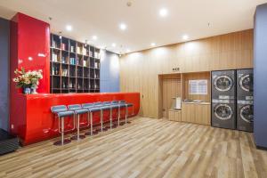 a laundry room with a row of chairs and a red wall at 北京刘家窑地铁站万信至格酒店 in Beijing