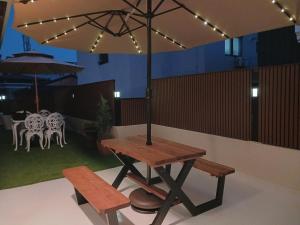 a picnic table with an umbrella and two benches at Stay Gaonhae in Gyeongju