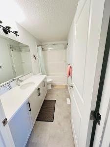 a bathroom with a sink and a toilet at Relax at The Hills at Ellerslie in Edmonton +49 photos