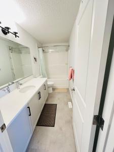 a bathroom with a sink and a mirror at Relax at The Hills at Ellerslie in Edmonton