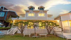 a large white house with two benches in front of it at Varadero Pension Taean in Taean