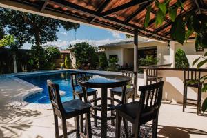 a patio with a table and chairs next to a swimming pool at Luxury Oasis in Las Colinas- Elegant 3-Bedroom Villa in Managua