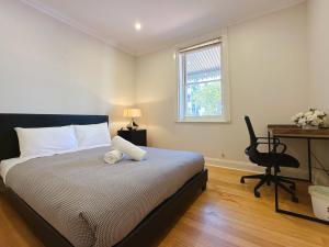 a bedroom with a bed with a desk and a chair at City Breeze BNB - Center Location in Hobart
