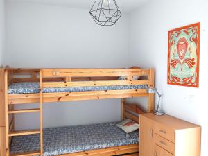 une chambre avec deux lits superposés et un bureau dans l'établissement Super Besse: Appartement 6 pers. lumineux avec balcon et cuisine équipée - FR-1-814-144, à Besse-et-Saint-Anastaise