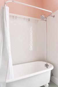 y baño con bañera blanca y cortina de ducha. en Red Brick Row by StayLage, en Saint Louis 18 fotos más