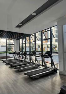 a row of treadmills in a gym with windows at K avenue condominium Studio in Donggongon