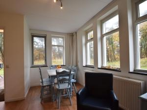 a dining room with windows and a table and chairs at Skyscraper apartment on the highest point with beautiful view in Bergen aan Zee +32 photos