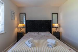 a bedroom with a large bed with towels on it at Walk to Liverpool Airport - Luxury Stay with EV Charge - Fast WiFi in Liverpool
