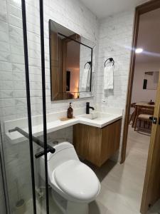 a bathroom with a toilet and a sink and a mirror at Apartamento en el parque principal con vista a la represa in Guatapé +17 photos