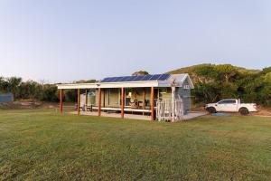 une maison avec un camion garé devant dans l'établissement Cottage 2 Cape Keppel Beach, à Curtis Island 7 autres photos