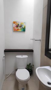 Un baño con un inodoro blanco y un lavabo. en NOKA ULUWATU BED And BREAKFAST, en Uluwatu