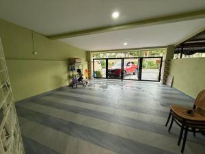 a living room with a child sitting on a scooter at Naura Homestay Batu Caves in Batu Caves
