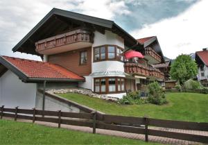 una casa grande en una colina con una valla en Alpenflair Ferienwohnungen Whg 201 "Doris" en Oberstdorf