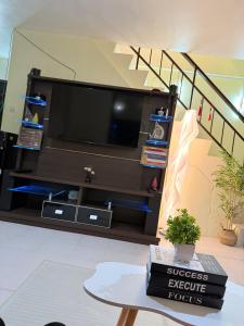a living room with a tv and a table at Chic &Cozy 3Bedroom House in Agus