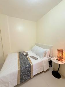 a bedroom with a bed and a table with a lamp at Chic &Cozy 3Bedroom House in Agus +33 photos