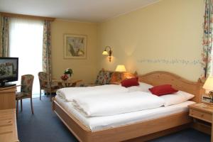 a bedroom with a large bed with white sheets and red pillows at Zilks Landgasthof Zum Frauenstein in Weiding