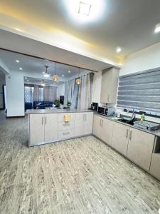 a large kitchen with white cabinets and a hardwood floor at Villa Azur in Grand Baie +12 photos