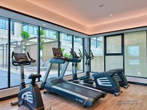 ein Fitnessstudio mit drei Crosstrainern und Fenstern in der Unterkunft Paradigm Residence Johor Bahru by Stayrene in Johor Bahru + 6 Fotos