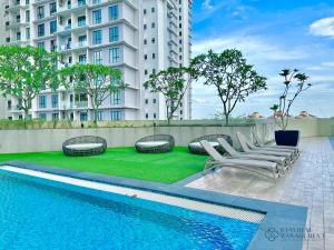 ein Swimmingpool mit Liegestühlen und ein Gebäude in der Unterkunft Paradigm Residence Johor Bahru by Stayrene in Johor Bahru