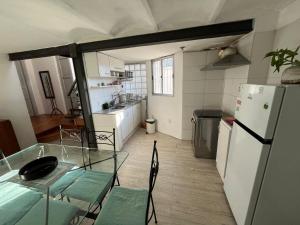 a kitchen with a glass table and a refrigerator at Charrúa1 in Montevideo