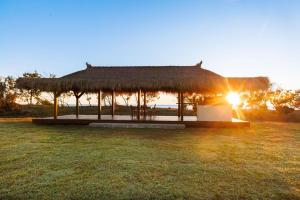 une cabane avec un toit d'herbe sur un champ dans l'établissement Cottage 1 Cape Keppel Beach, à Curtis Island 13 autres photos