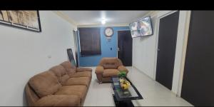 a living room with a couch and two chairs and a clock at CASA con 2 habitaciones, Cocina,comedor y baño privados in Candelaria