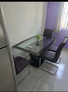 a glass table and chairs in a room at CASA con 2 habitaciones, Cocina,comedor y baño privados in Candelaria +3 photos