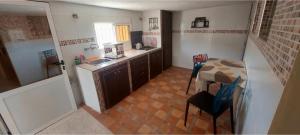 a small kitchen with a table and a sink at Dar Elbiad A1, duplex très mignon in Ifargane