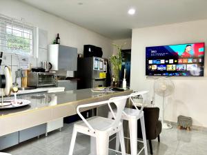 a kitchen with a counter and two white stools at The Almas Apartment in Willemstad