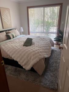 a bedroom with a bed with a book on it at Greenwood Cottages in Tolmie
