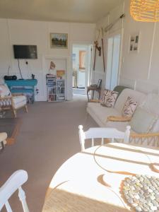 un soggiorno con divani e tavolo da biliardo di CROOKED MILE COTTAGE - BY THE SEA history and charm a Hokitika
