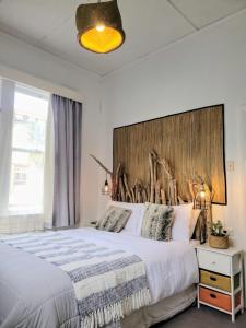 una camera da letto con un letto con testiera in legno di CROOKED MILE COTTAGE - BY THE SEA history and charm a Hokitika