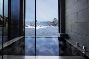 a glass door with a view of the water at Hakuba Amber Echoland MrT by Jade Villa in Hakuba