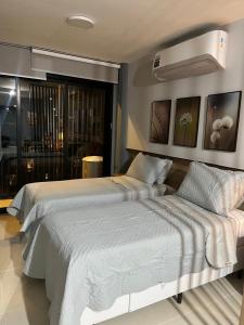 SkyLux Studio Novo e Confortável no Centro في ريو دي جانيرو: غرفة نوم بها سريرين ونافذة كبيرة