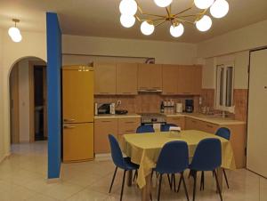 a kitchen with a table and chairs and a kitchen with a yellow refrigerator at Casa Azul Nea Makri in Nea Makri