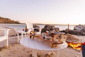 une table de pique-nique sur la plage à côté de l'océan dans l'établissement Cottage 4 Cape Keppel Beach, à Curtis Island
