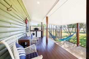 un porche avec des balançoires et un hamac sur une maison dans l'établissement Cottage 4 Cape Keppel Beach, à Curtis Island 9 autres photos